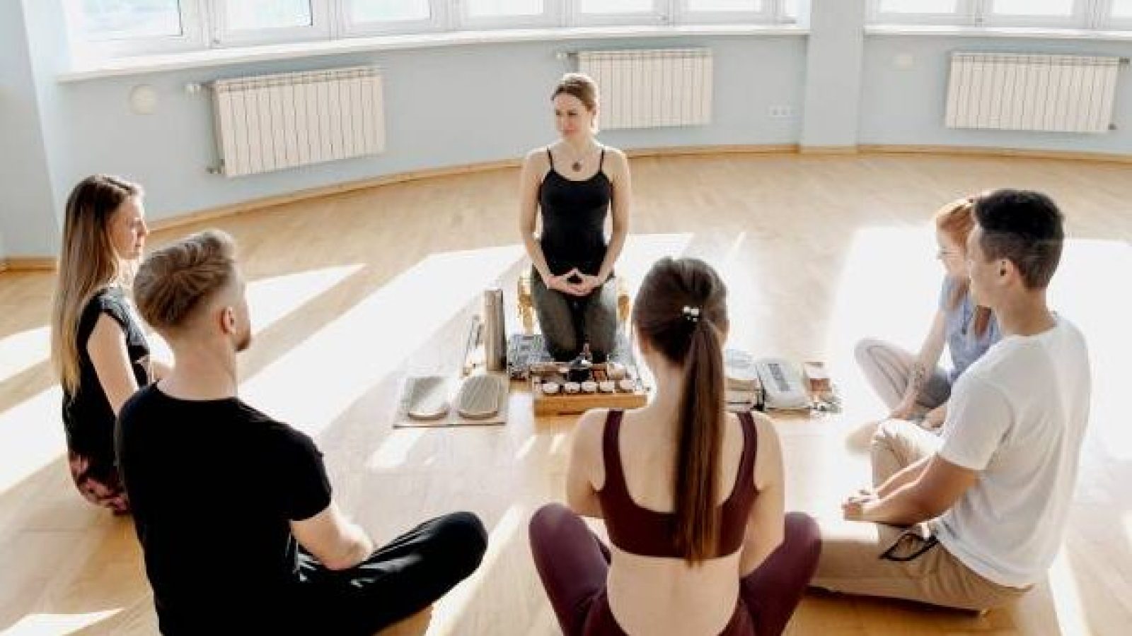 group-of-people-meditating-together-in-a-bright-skyrise-studio